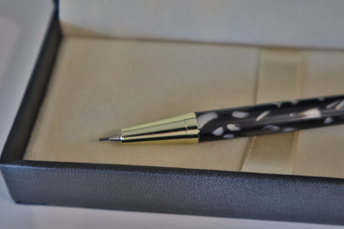 Close-up of handmade black acrylic click pencil tip and gold-tone fittings